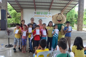 (L-R) Students receiving their certificates together with Vivian Odiame â€“ Principal of Santiago 1, Glenda Magpantay â€“ AVP for Operations of CARD Bank, Raquel Zaragosa â€“ Regional Director of CARD Bank, Arlene Corbantes â€“ Area Manager of CARD Bank and CARDEE â€“ official mascot of CARD Bank. 